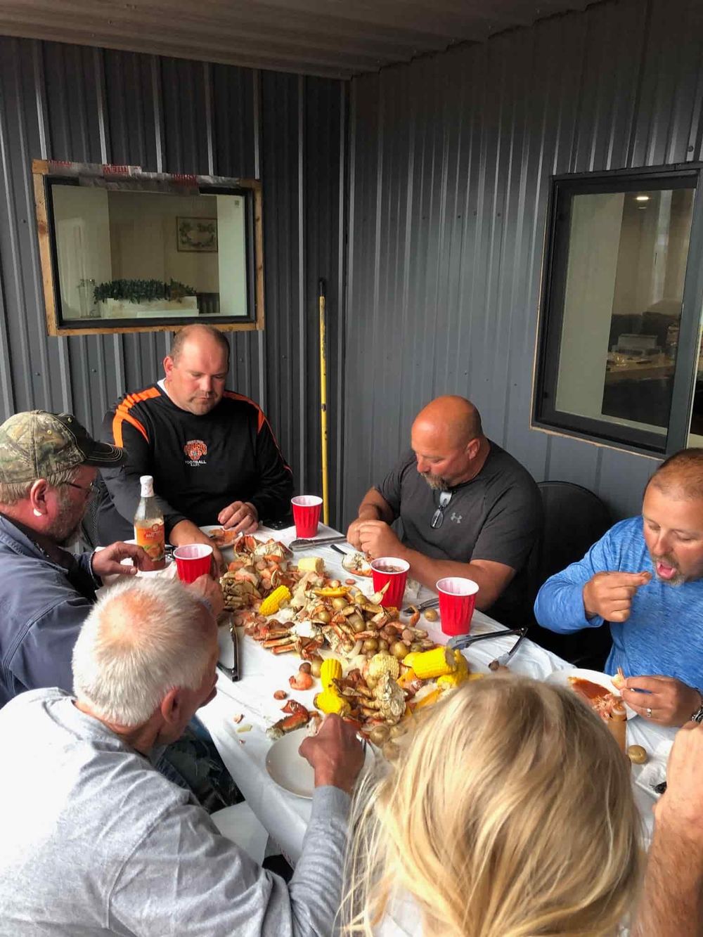Lodge guests around the table at Eagle Rock Lodge sharing a seafood dinner