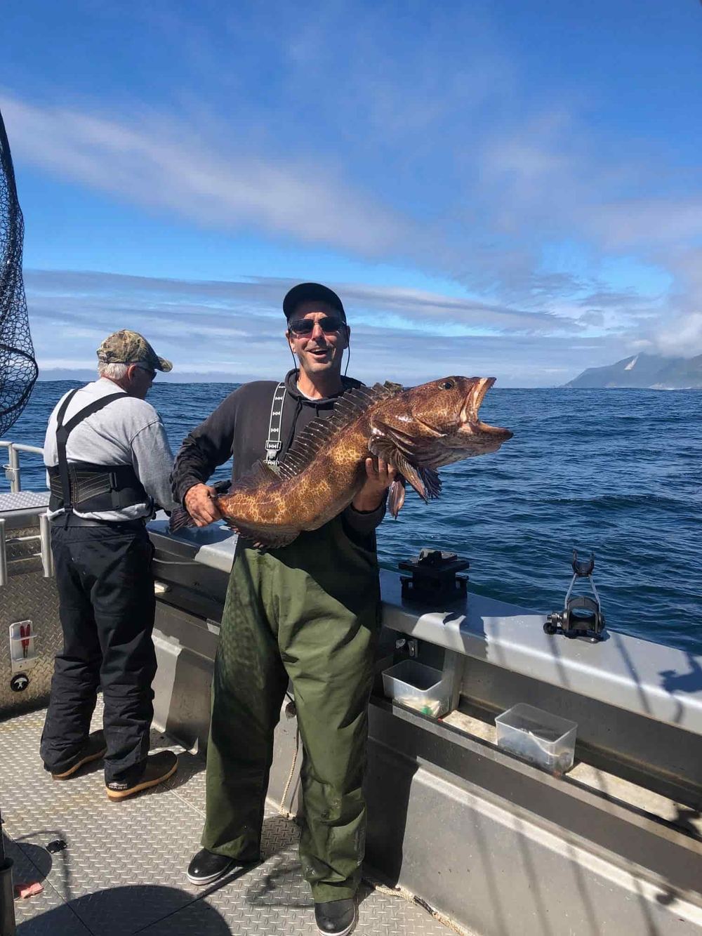 Angler holding a lingcod caught bottom fishing in the waters off Prince of Wales Island